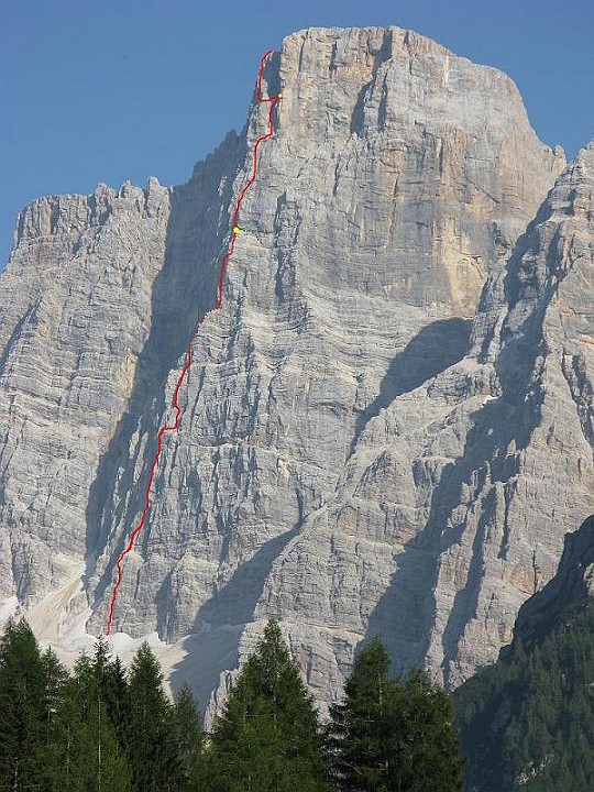 Traccia P.Fiume.JPG - Grandiosa via su un'enorme parete. Di gran lunga la scalata più impegnativa da me offrontata ( anche se da secondo ). Sono 1000 m di sviluppo, una 30 di tiri circa. Dal pilastro Fiume vero e proprio che termina dove c'è il primo pallino giallo si esce in cima con la via "Simon Rossi" e varianti. La scalata ci ha impegnato per 14 ore di arrampicata, bivacco alla base e secondo bivacco in parete a due tiri dall'uscita. Arrampicata impegnativa anche per parecchi tiri con roccia friabile e chiodatura pressoché assente fino all'incontro con la via Simon Rossi. Un'esperienza intensa e indimenticabile con i miei amici Beppe e Filippo. La relazione tratta dalla guida "Pelmo e dolomiti di Zoldo" è scaricabile da qui: http://www.trafoconsult.com/climbing/PelmoPilastroFiume/PelmoPilastroFiume.pdfAbbiamo trovato la relazione piuttosto imprecisa ...